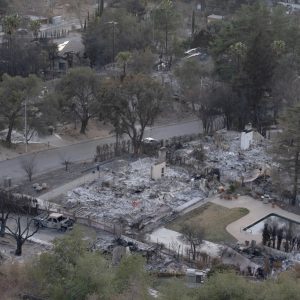 An aerial view shows at least three burned-down homes and charred trees in Altadena from the Eaton Fire.