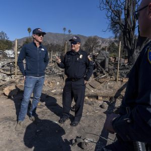 Gov. Gavin Newsom, at left, tours fire destruction in LA County with local first responders.