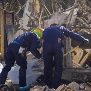 Workers clear fire debris.