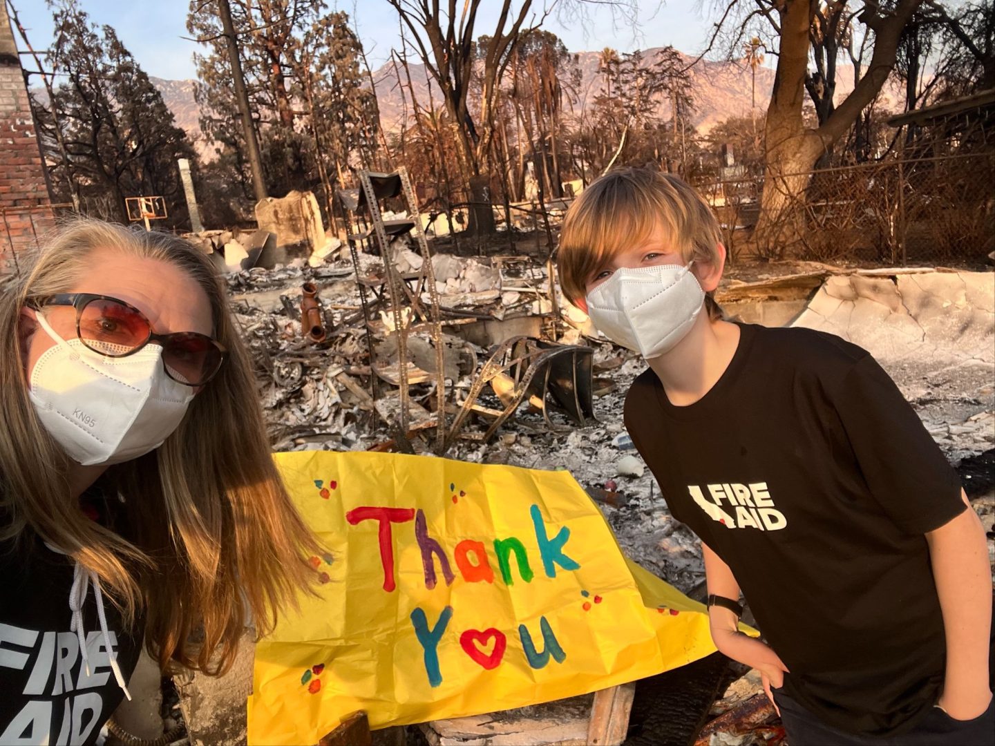 Kelsey Brown and her son Calder thank first responders in front of the remains of their Altadena home.