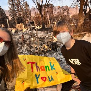 Kelsey Brown and her son Calder thank first responders in front of the remains of their Altadena home.